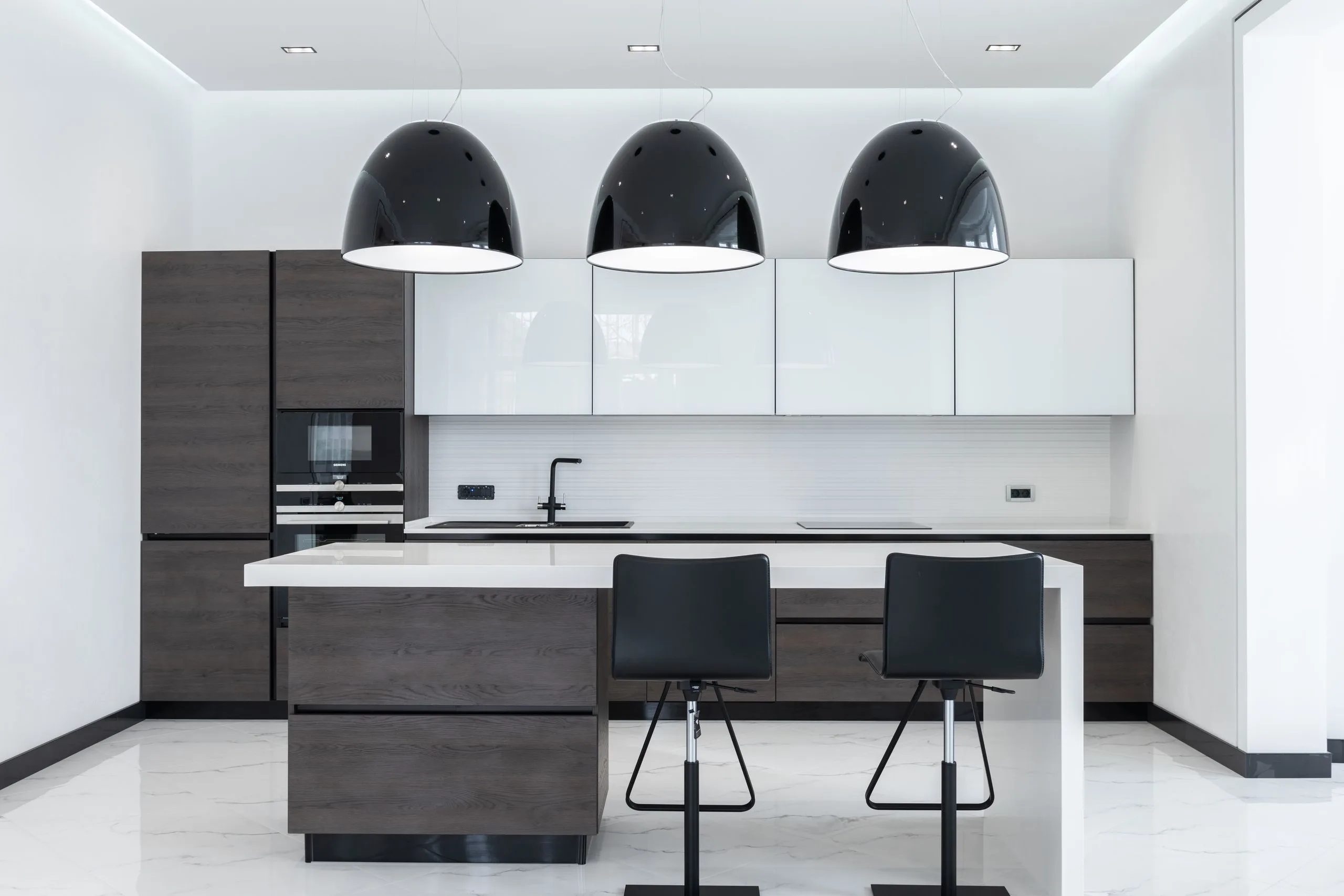 Cuisine moderne en bois clair avec suspensions au-dessus de l'îlot et ruban LED sous les meubles hauts