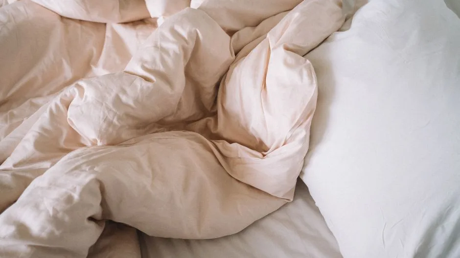 Linge de lit en lin défait puis refait dans la chambre